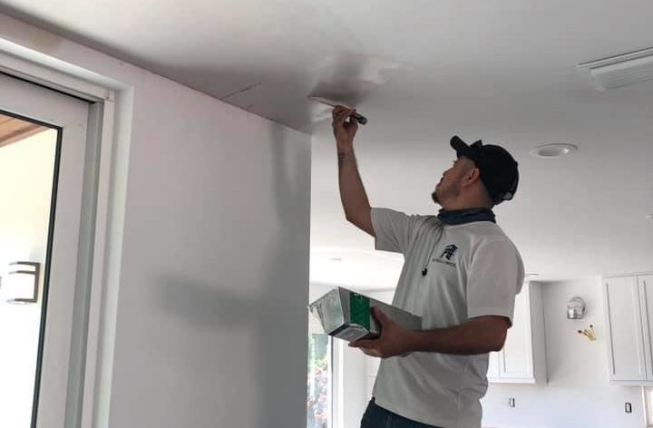 Man painting ceiling white